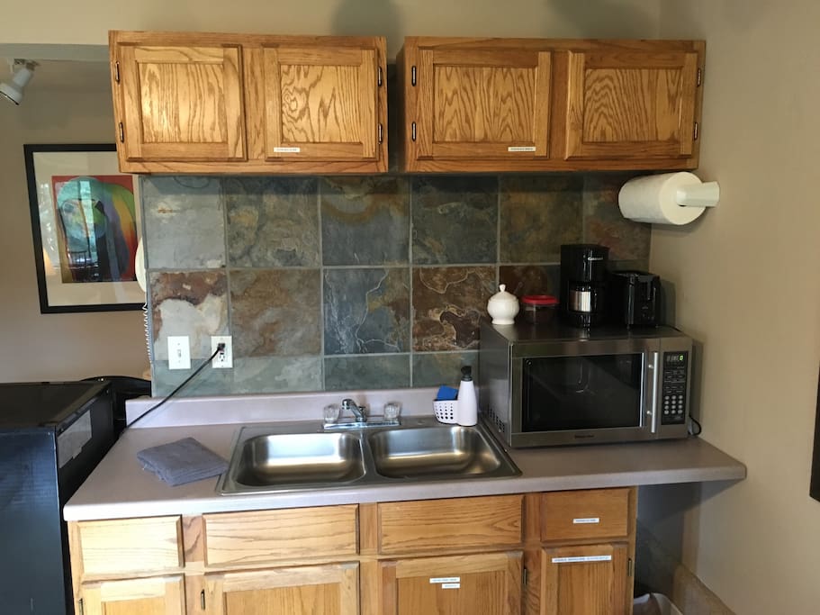 Kitchenette with refrigerator/freezer, microwave, coffee and coffee maker.