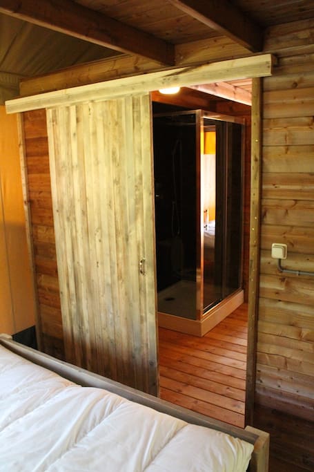 Badkamer met douche, toilet en wasmeubel.