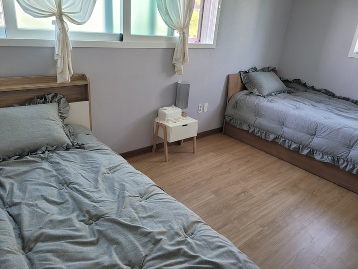 Dhoma e gjumit në katin e parë. Ka 2 krevate super tek/kondicioner tavani/ndriçim/tavolinë anësore/hekur me avull etj.