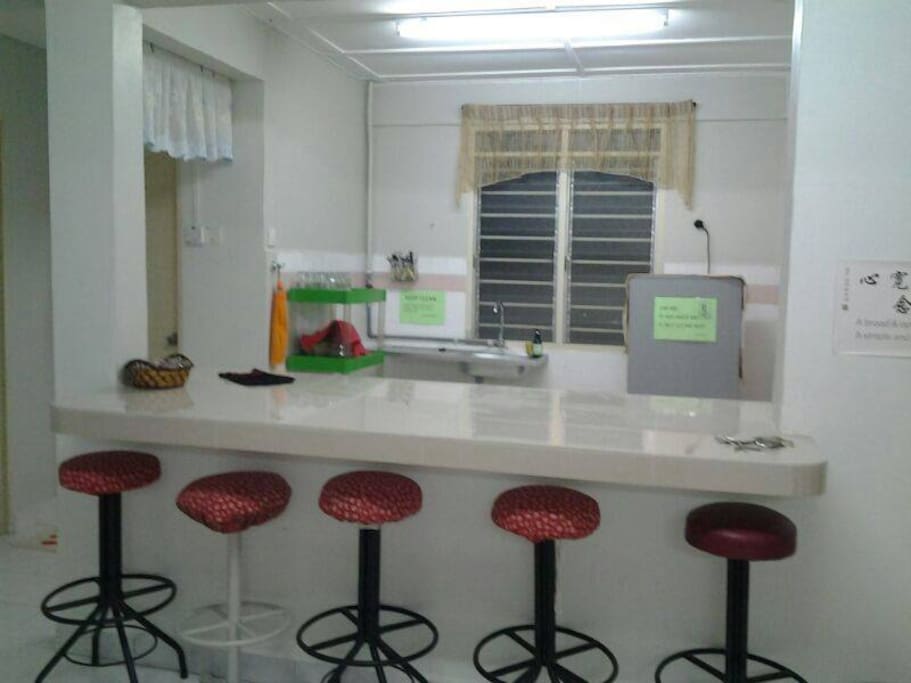 Kitchen with kettle, fridge and dining place.