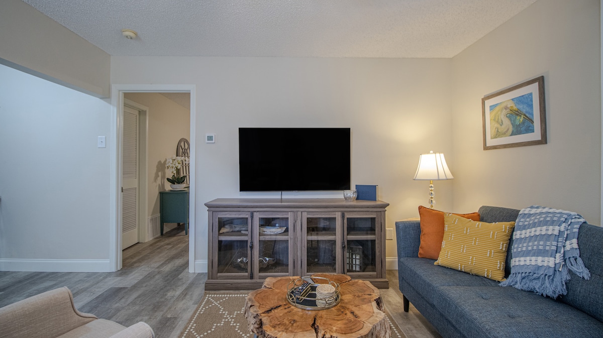 Obývacia izba s 55-palcovou inteligentnou TV. Prihláste sa do streamovacích aplikácií, ako sú Netflix, Hulu, Amazon Prime a Disney+