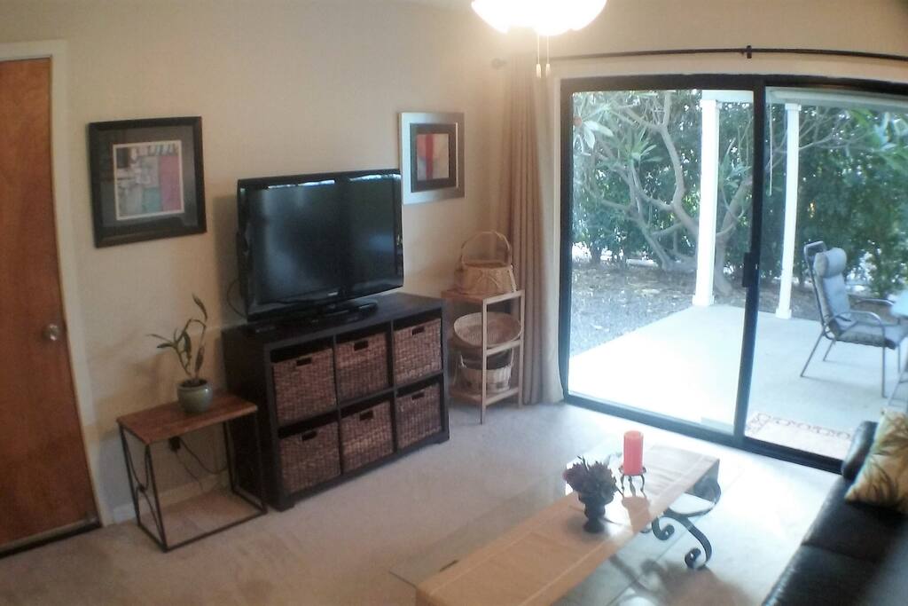sitting room with flat panel TV and glass sliding door to patio