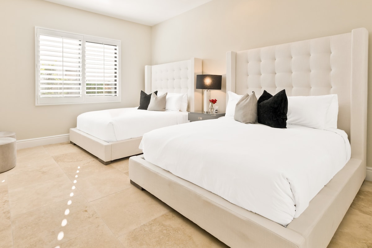 Bedroom 2 with two queen sized beds, closet and tv.