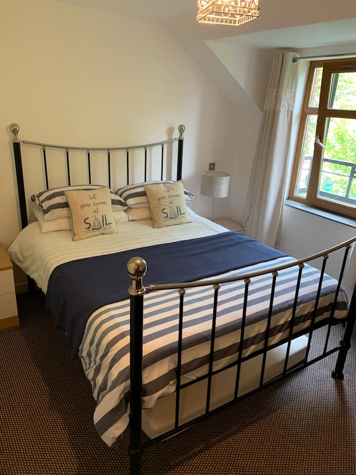 Cama tamaño king y cama individual en el piso superior de la casa. 