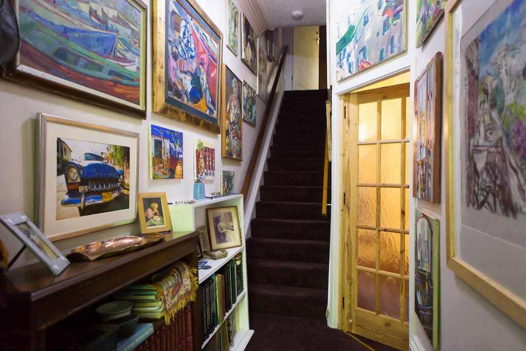 Main entrance hallway filled with my oil paintings and photographs. These stairs lead up to your room.