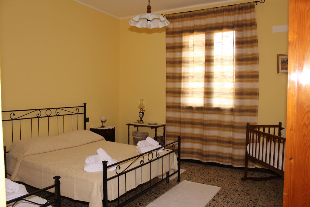 camera da letto con matrimoniale e letto singolo con una culla per bimbi