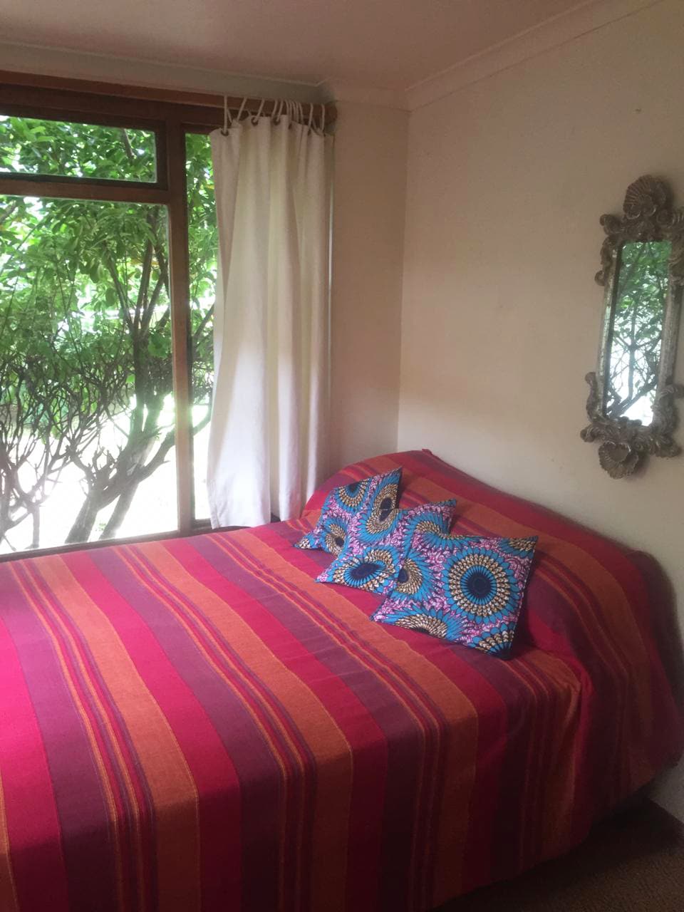 一间卧室有一张双人床，有一扇通往后花园的门。 请注意，这个房间没有通往房子其他地方的普通门，而是一个织物窗帘