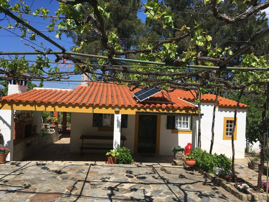 Exterior da casa. Frente da casa com estacionamento, esplanada, telheiro, jardim e churrasqueira.