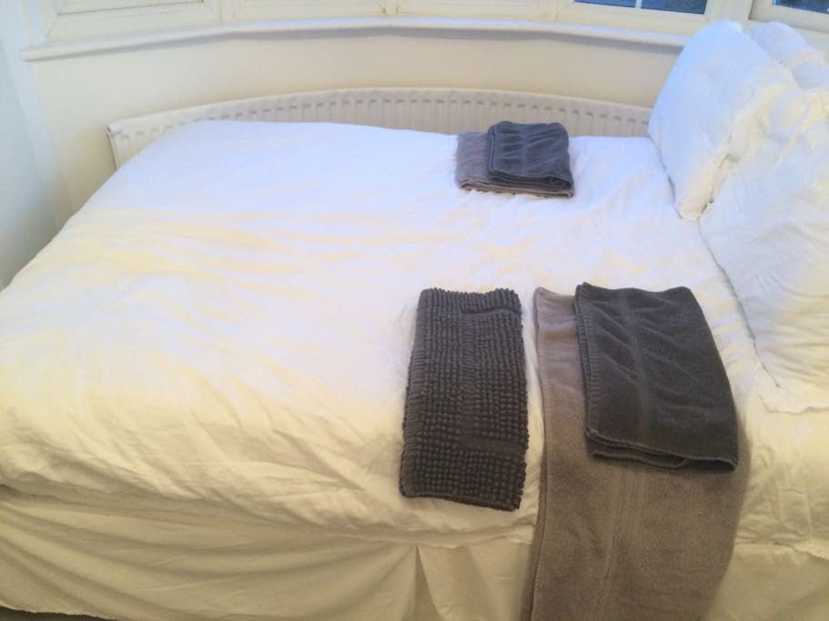 Close up of the double bed with Egyptian cotton 300 thread count sheets, Egyptian cotton bath towels, Egyptian cotton hand towels and bath mat. Two pillows per person so that is four pillows in total. Vallance to cover base of bed. Windows may be opened or closed. Blinds to keep out light.