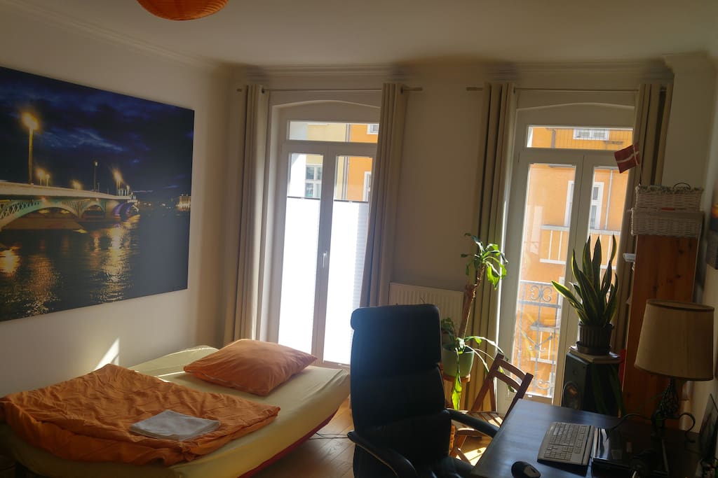 Guestroom including work desk and access to balcony