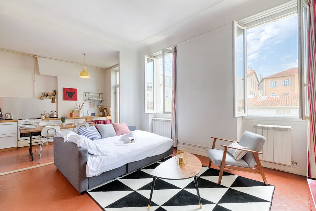 Spacious and sunny living room with its confortable double couch bed