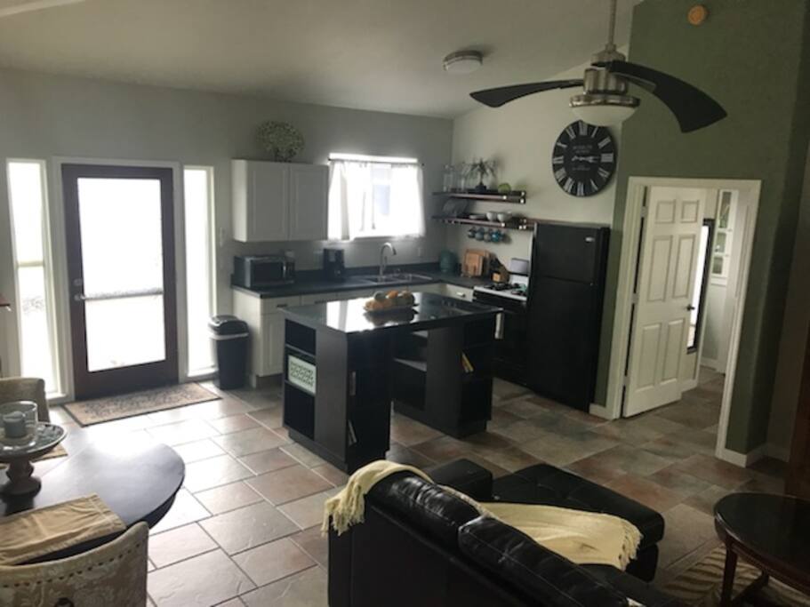 View of the kitchen with the front door on the left and the bedroom door on the right.