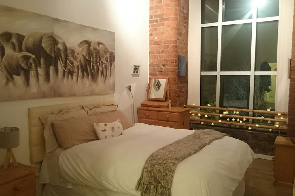 King size bed with high ceilings and exposed brick