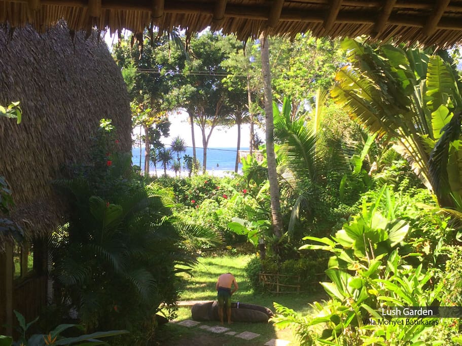 View of lush garden from Family Surf Bungalow's balcony