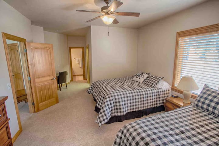 Dormitorio loft sur con dos camas tamaño queen, baño completo privado, escritorio y vestidor. 