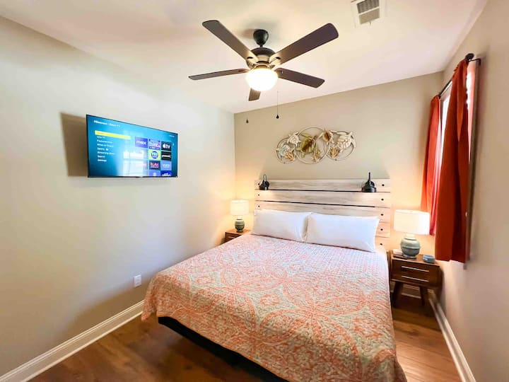 Second bedroom, equipped with a king bed, two nightstands, reading lamps, and a 43 inch smart TV.