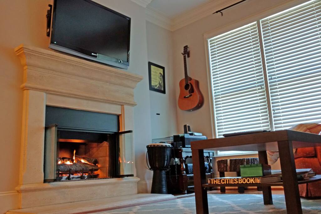 Gas fireplace in living room with flat screen TV and windows for lovely lighting looking over the pool area.