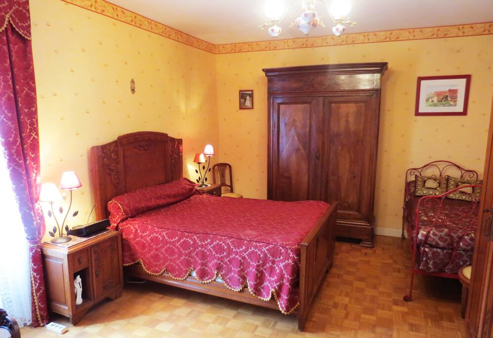 La chambre rouge avec 1 lit double et 1 simple