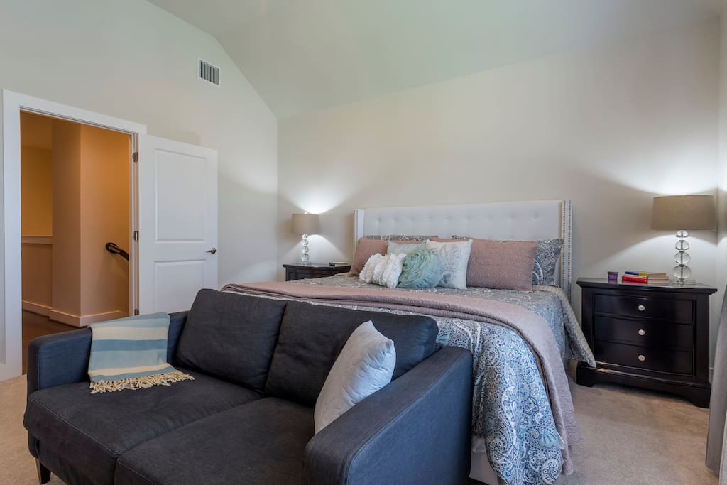 Master bedroom has a king-sized bed with couch for extra seating