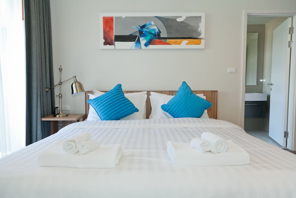 Comfortable bedroom with calm abstract paint by local artist