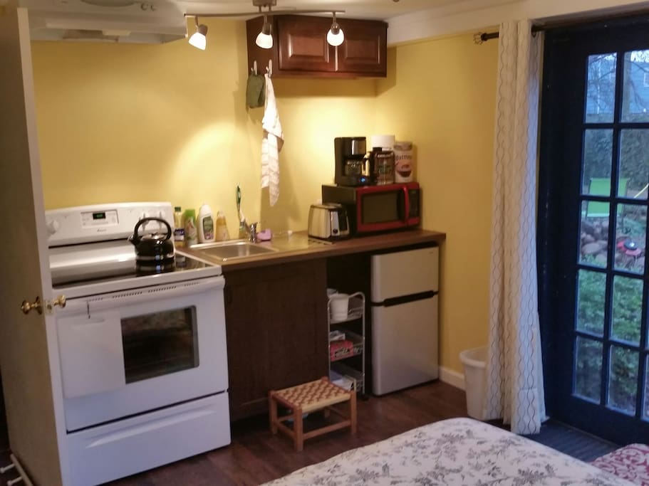 Kitchenette complete with full size stove, mini fridge, microwave, and coffeemaker
