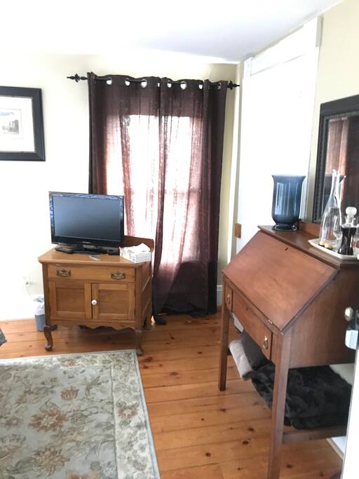 Entrance of bedroom with television and desk.