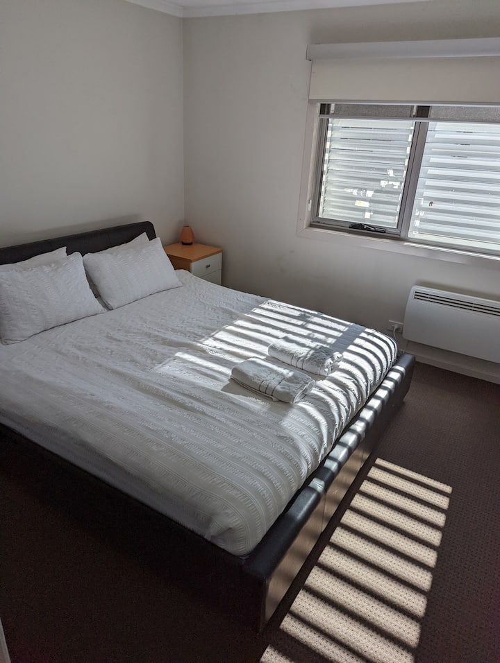 Спалня 1, със самостоятелен санитарен възел. Голямо двойно легло. Две странични маси и вградени гардероби. 