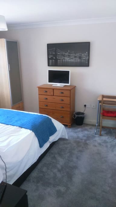 Bedroom has TV/DVD, wardrobe, chest of drawers and a desk and chair