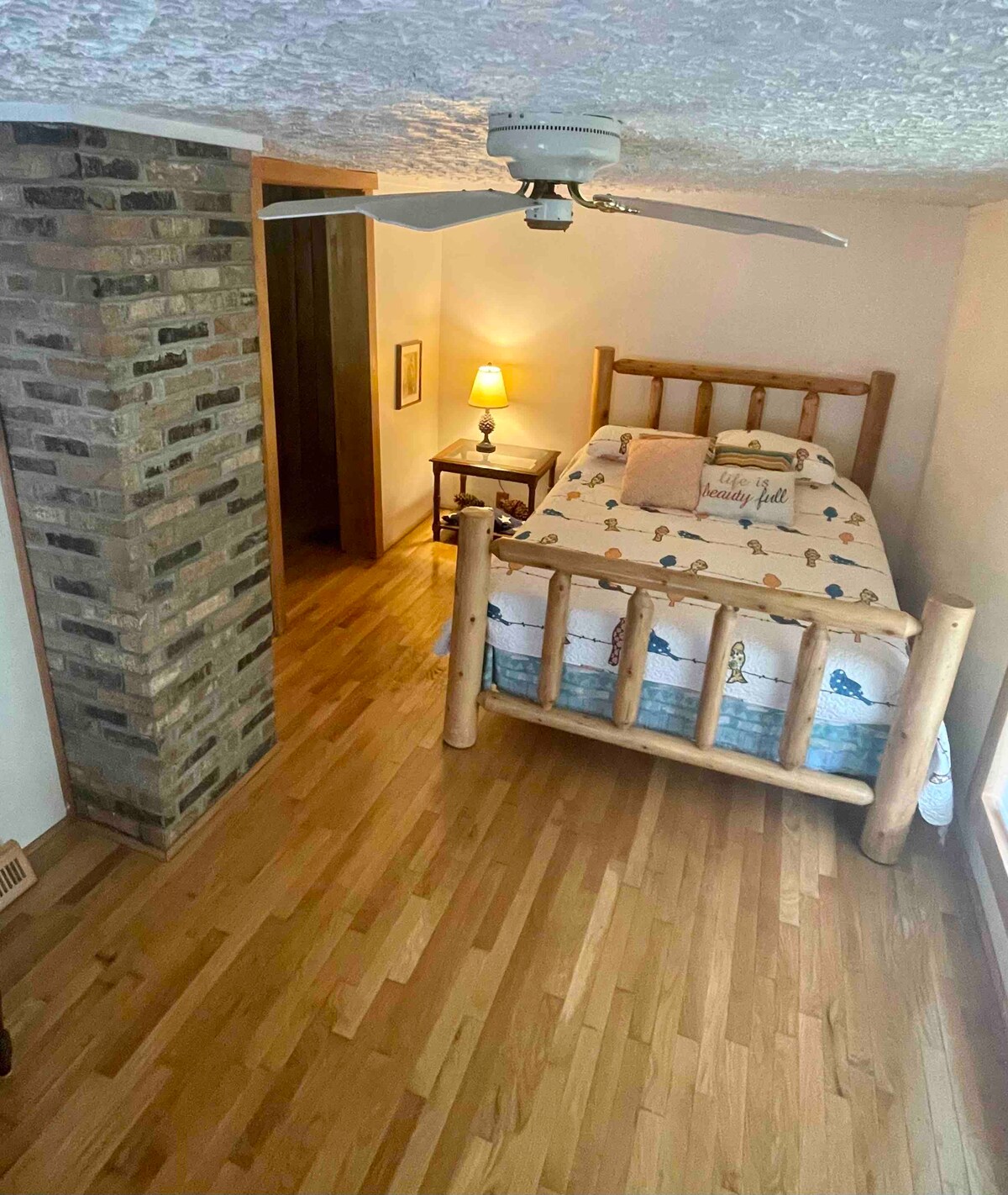 The second main floor bedroom has a log queen bed. 