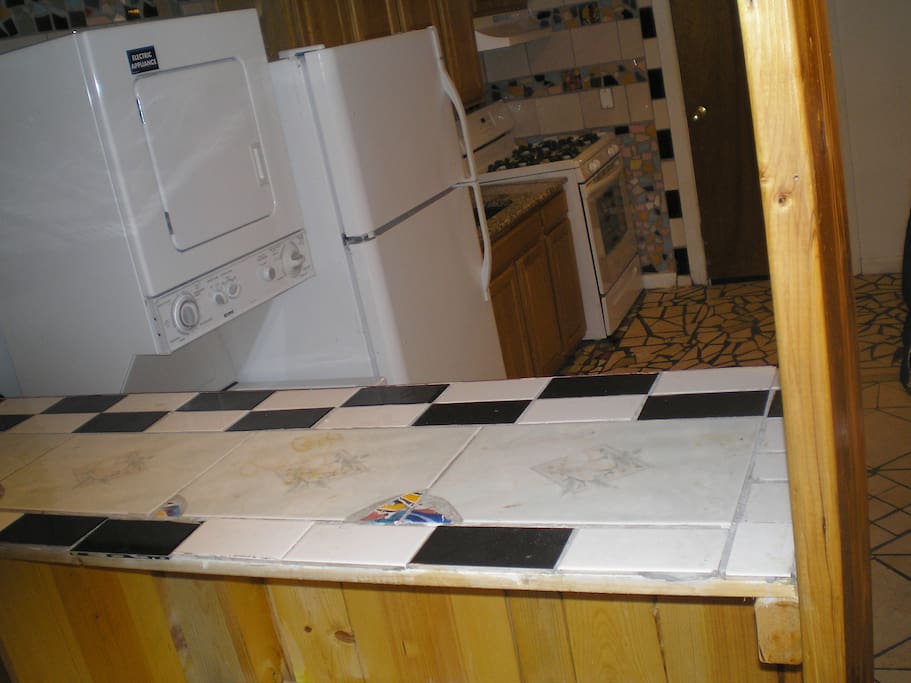 View of a Full Bar, and area with washer/Dryer & Fridge