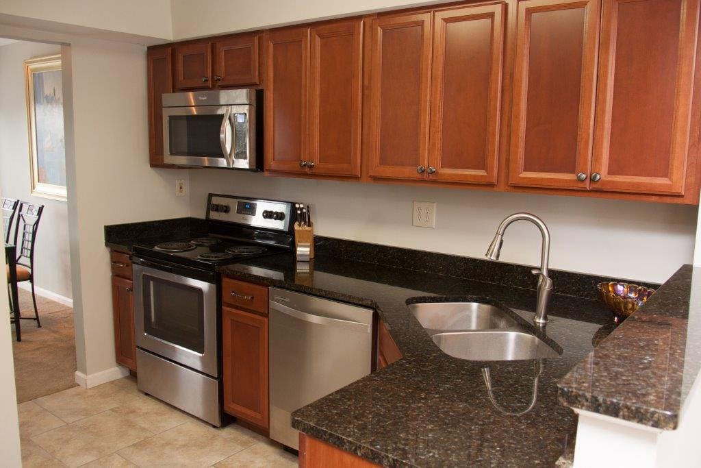 Kitchen offers custom cherry cabinetry, deep stainless steel sink, stainless steel appliances and granite counter tops