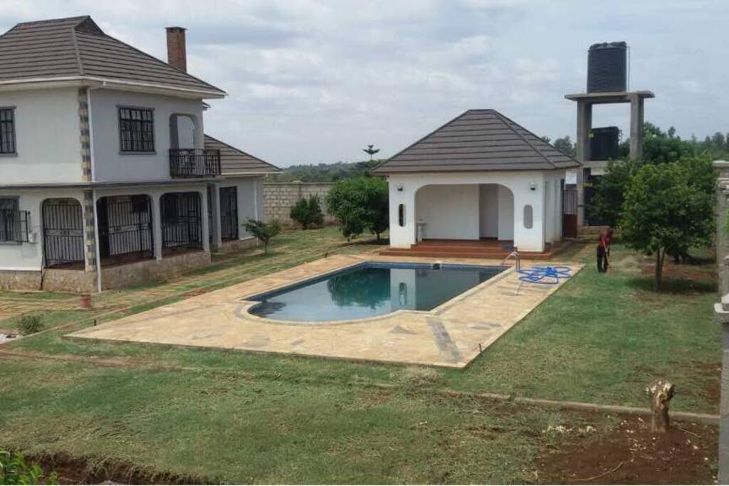 a pool and pool house with shower ;counter and pump