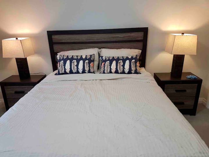 Master bedroom with double closet and large dresser with mirror.