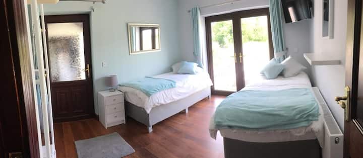 غرفة نوم خلفية مع أسرّة منفصلة.