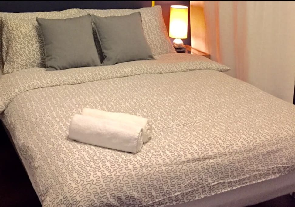 Queen bed with bed sets and towels provided.