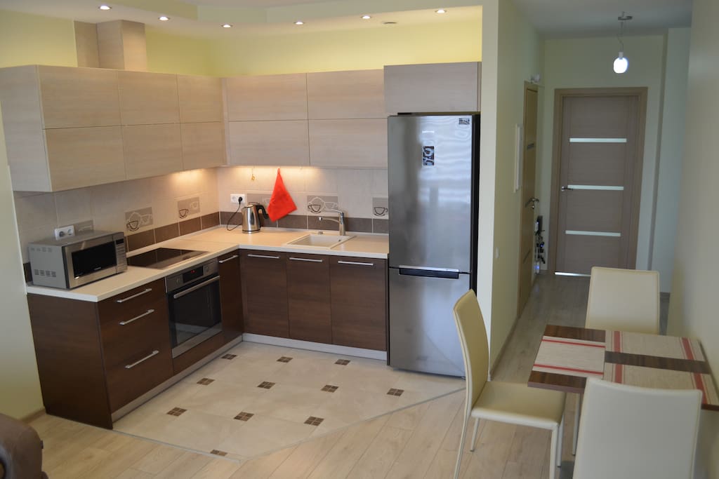 Fully equipped kitchen has everything that you might need - refrigerator, dishwasher, cooker hood, induction hob, oven, microwave, kettle, pots and tools.