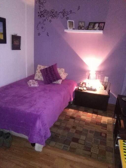 Dormitorio con cama matrimonial, ropero, tv, ventanal y acceso al baño