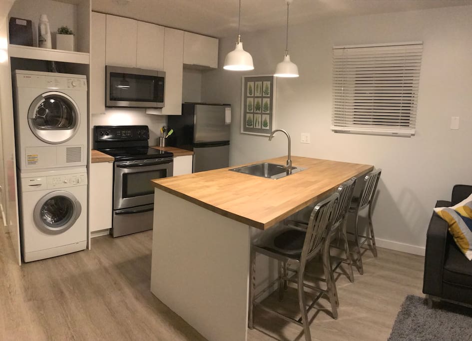 Kitchen with all the essentials, including a stacking washer/dryer for laundry.