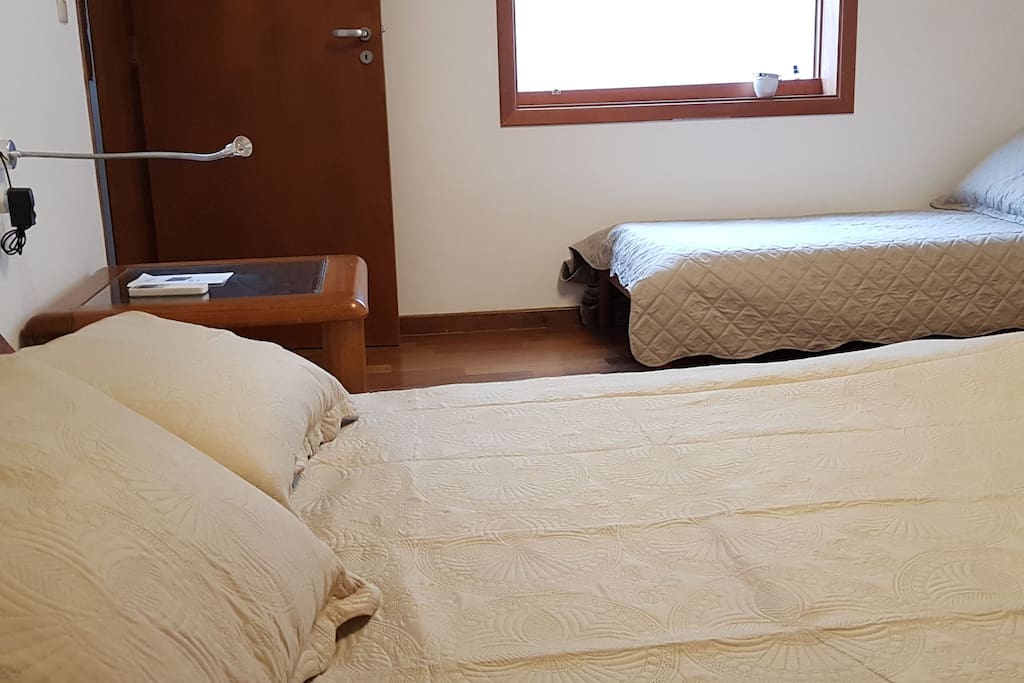 Cama de casal queen size. amplas mesas de cabeceira, luminárias de leitura ultra práticas, cama de solteiro adicional.