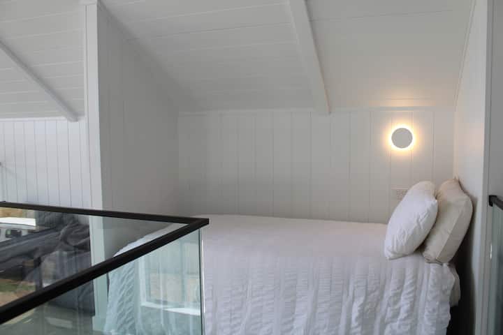 Single bed on Mezzanine level, with incredible views through the floor to ceiling glass wall