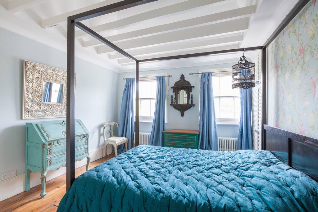 Bedroom with four poster bed and pitched ceiling