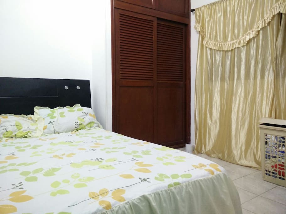 Al igual que la otra habitación esta tiene cama doble, abanico, closet y dos ventanas. Habitación cómoda, amplia y al mismo tiempo bastante fresca.
Same as the other room, it has a bed (double), fan, closet and two windows. Comfortable room with enough space to put your belongings. I like this one because it's very fresh; lot's of air in here.