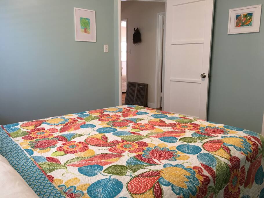 Bedroom 2: Queen bed, evening sun in the window behind bed