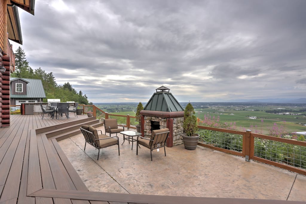 The cliff side deck with a full outdoor kitchen and fireplace offers a cozy and comfortable area to dine, relax, and enjoy the views of the valley far below