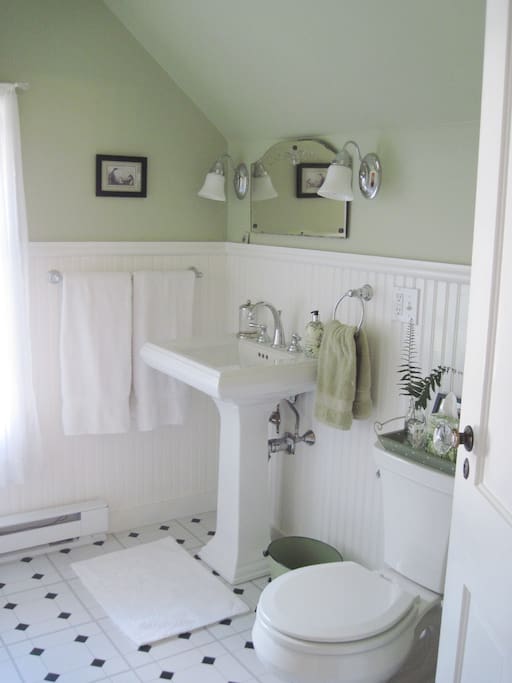 A relaxing private bathroom, en suite, with a small closet for hanging clothes in.