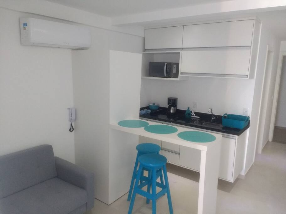 Saleta com TV e cozinha americana