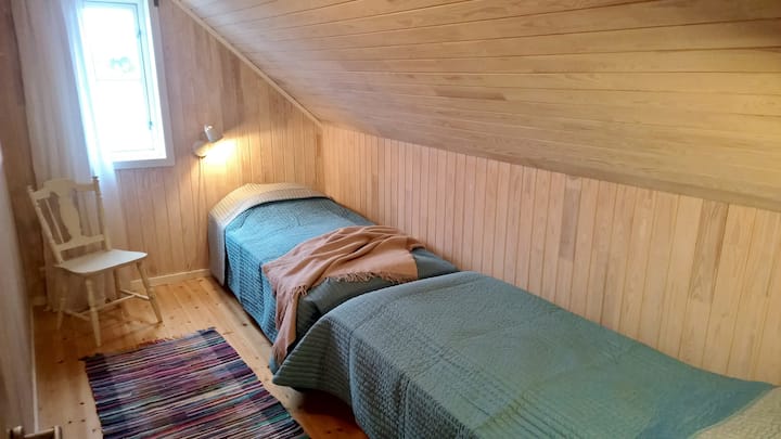 Spavaća soba s dva odvojena kreveta koji se lako mogu namjestiti na bračni krevet. Pogled na fjord.  