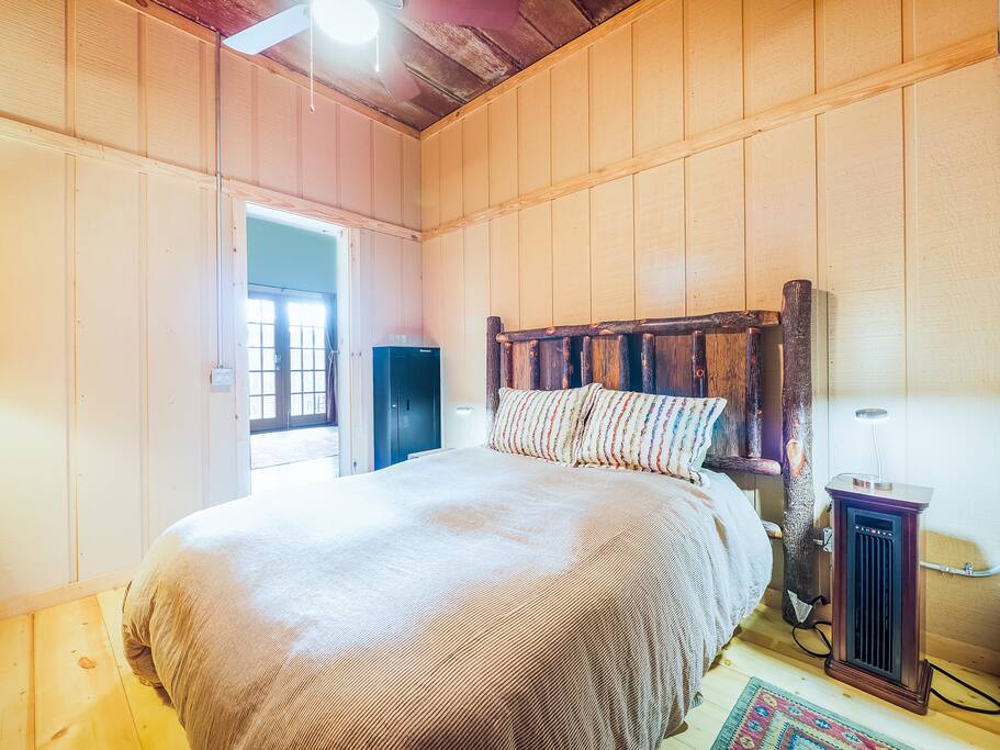 The queen bed in the rustic room.