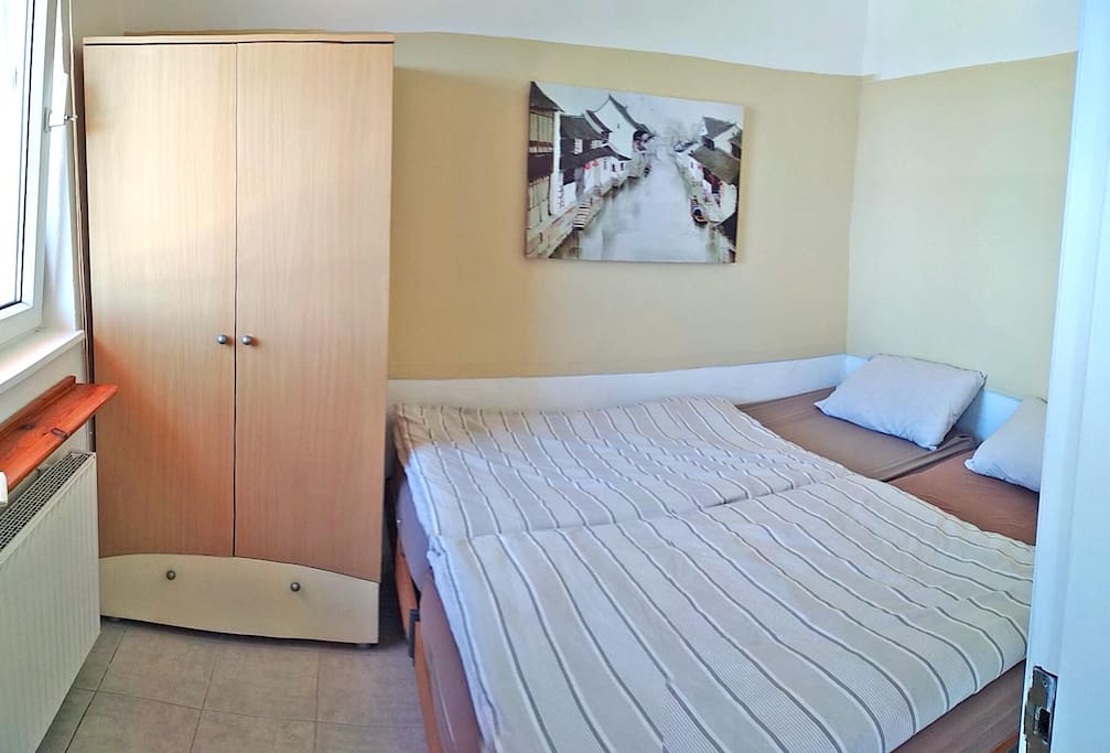 Schlafzimmer mit Schrank, 2 Einzelbetten als großes Doppelbett und Heizung/Deckenventilator