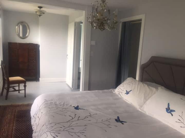 Chumba cha kulala cha Master kilicho na ukuta wa madirisha kuelekea ziwa